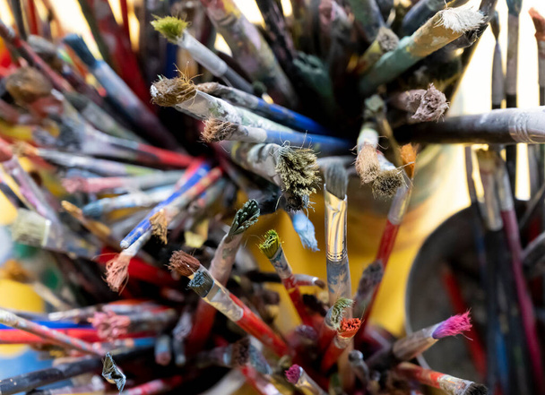 Un sacco di pennelli per artisti sporchi in un secchio. Pennelli per artisti diversi, vista da vicino - Foto, immagini