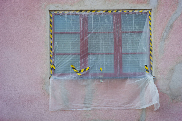 окно на здании под реставрацию, розовая стена, покрытая пластиком - Фото, изображение