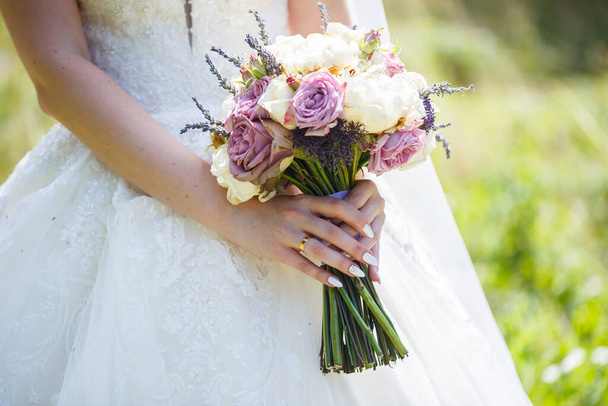 Beautiful wedding bouquet of flowers in the hands of the newlyweds - Foto, imagen