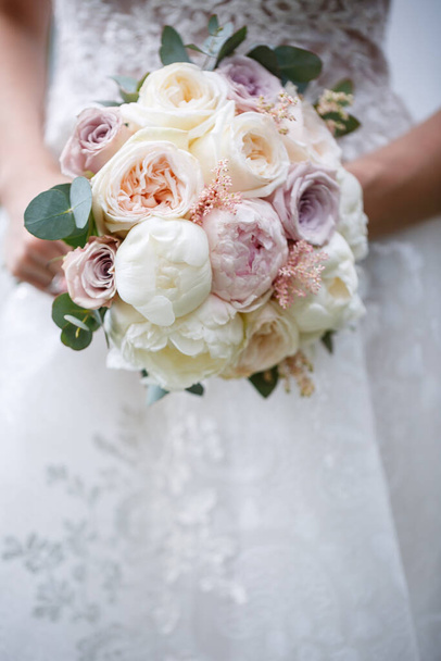 Beautiful wedding bouquet of flowers in the hands of the newlyweds - Photo, Image