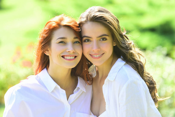 Positive young girlfriends hagging and having fun over green nature background, outside. Woman Apparel, Garments Clothing. - Fotoğraf, Görsel