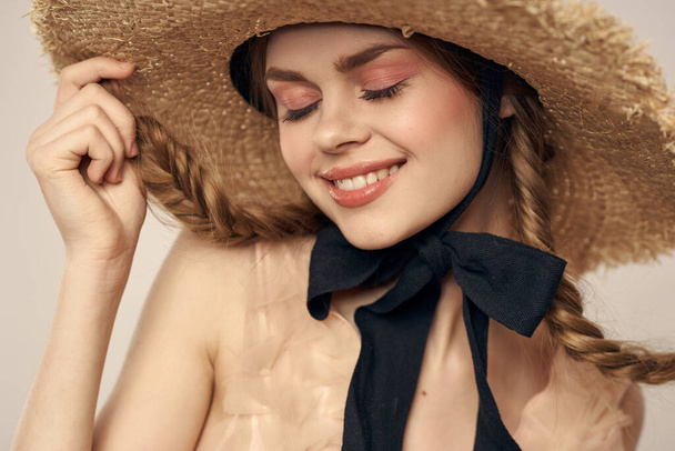 cute girl in straw hat with black ribbon and dress on beige background cropped view - Photo, Image