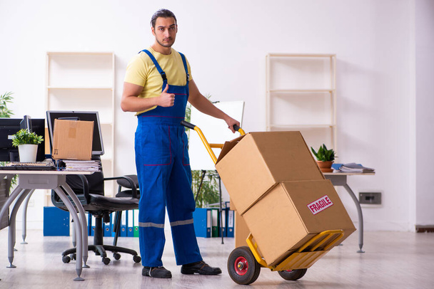 Young male contractor in moving concept - 写真・画像