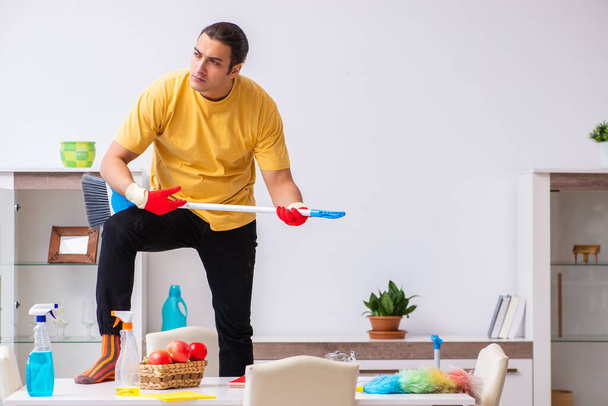 Joven contratista masculino limpiando la casa - Foto, Imagen