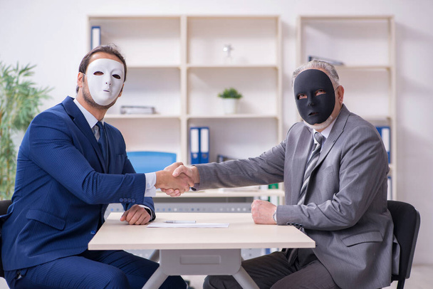 Dwóch biznesmenów w maskach podczas negocjacji - Zdjęcie, obraz