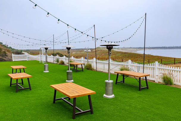 Outdoor seating at a beachfront restaurant empty due to the pandemic, Half Moon Bay near San Francisco, Pacific Ocean in the background on a foggy day - Photo, Image