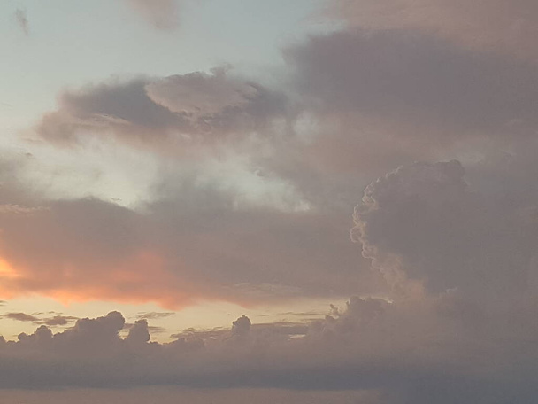 Oranje en witte wolk, dramatische blauwe lucht Achtergrond voor zonsondergang. - Foto, afbeelding