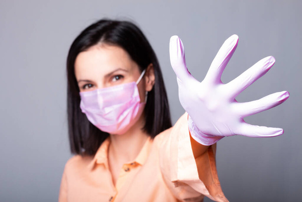 woman in shirt, medical mask and gloves, gray background - Фото, зображення