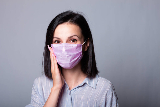 girl in in a shirt  and a pink medical mask on her face - Foto, Imagem