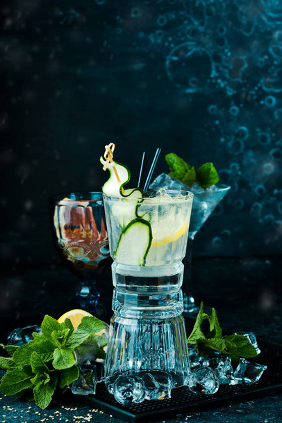 Alcoholic cocktail: Gin and tonic with cucumber on a black stone background. Menu bar. Alcohol. - Foto, Bild