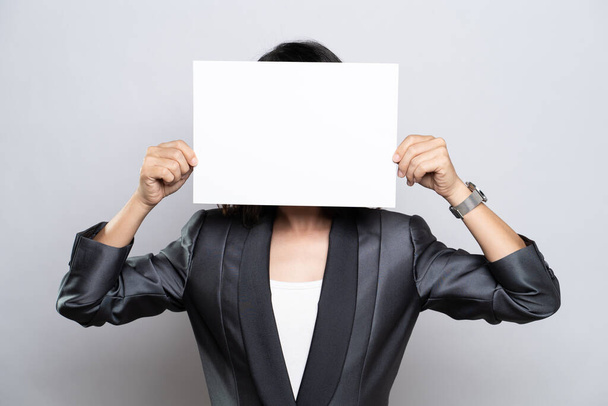Business woman showing paper cover her face isolated over white background - Photo, Image
