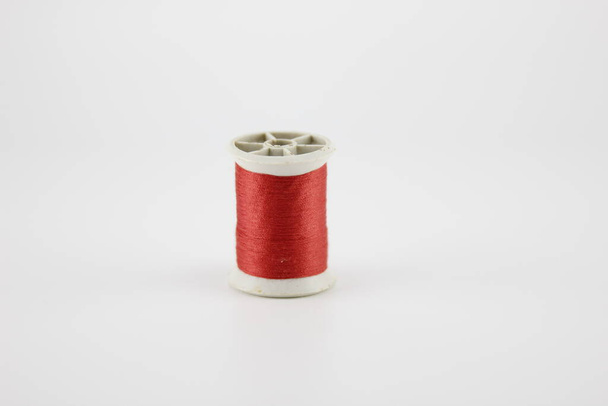 Red sewing thread Put on a white background - Foto, afbeelding