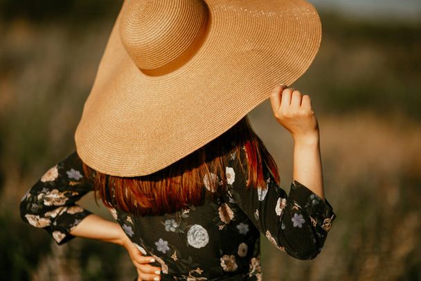 Young woman with a summer big straw hat in the field - Photo, Image