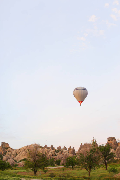 Globo de aire caliente volando sobre rocas Capadocia, Turquía. - Foto, Imagen