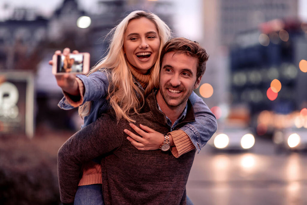 Onnellinen nuori pari ottaa selfie kadulla.  - Valokuva, kuva