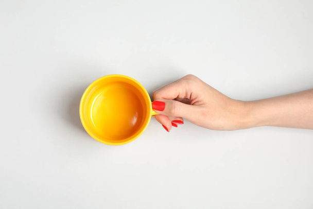 Woman with empty cup on light background, top view - Foto, Imagem