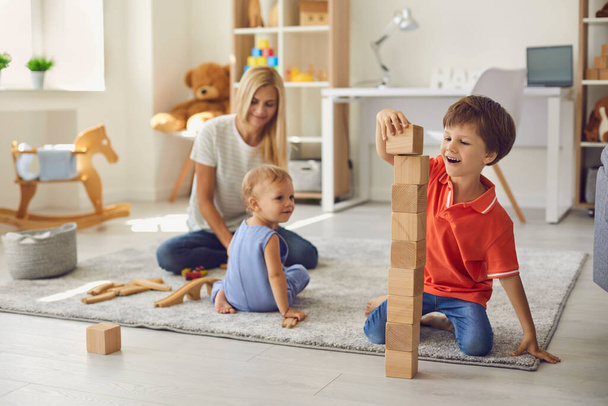 Mother playing with happy children on floor at home - Fotografie, Obrázek