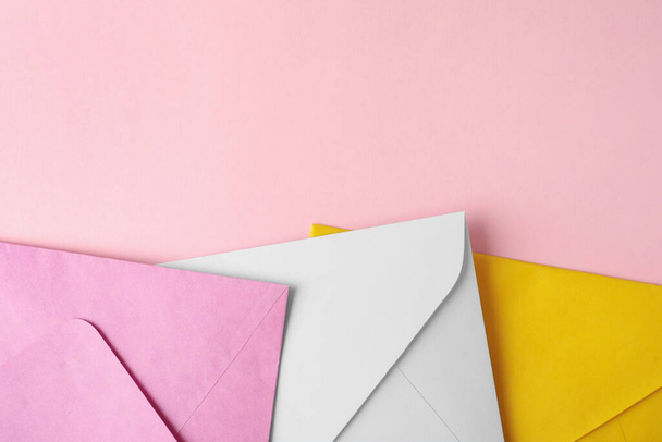Colorful paper envelopes on pink background, flat lay. Space for text - Zdjęcie, obraz