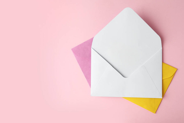 Colorful paper envelopes on pink background, top view. Space for text - Fotó, kép
