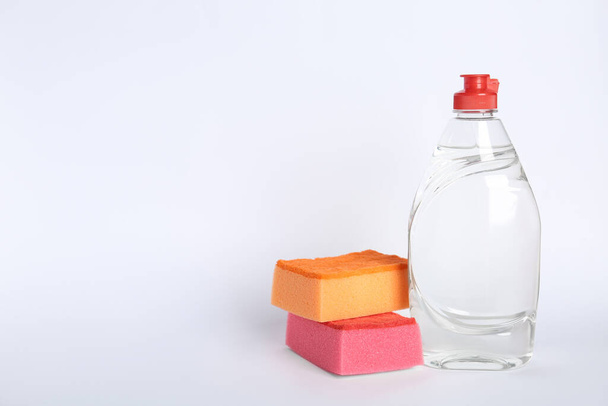 Bottle of detergent and sponges on white background - Photo, Image