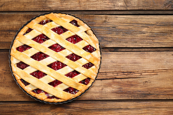 Delicious fresh cherry pie on wooden table, top view. Space for text - Фото, изображение