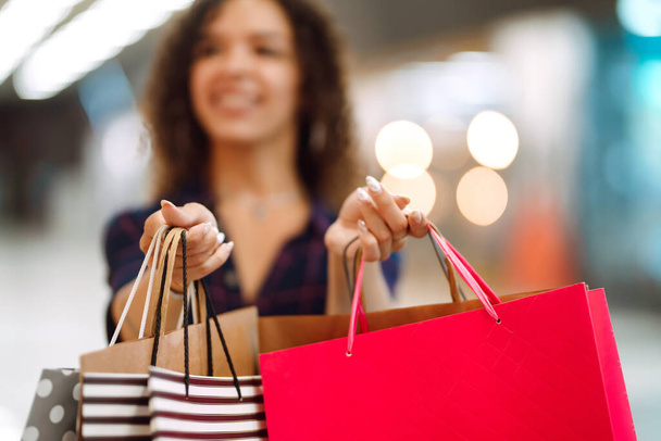 Shopping bags in the hands. Young woman with packages after shopping. Purchases, black friday, discounts, sale concept. - Φωτογραφία, εικόνα