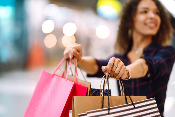 Shopping bags in the hands. Young woman with packages after shopping. Purchases, black friday, discounts, sale concept. - Φωτογραφία, εικόνα