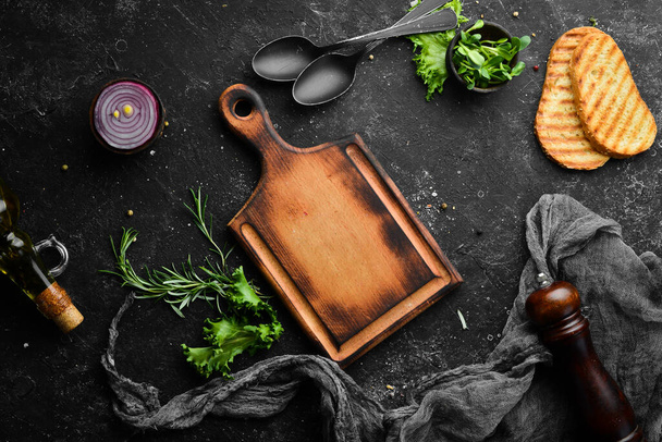 Black stone background: kitchen board, vegetables and spices. Top view. Free copy space. - Photo, image