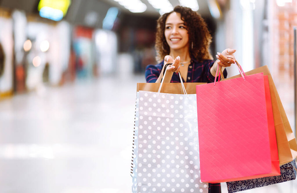 Shopping bags in the hands. Young woman with packages after shopping. Purchases, black friday, discounts, sale concept. - Valokuva, kuva