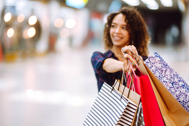 Shopping bags in the hands. Young woman with packages after shopping. Purchases, black friday, discounts, sale concept. - Foto, Bild