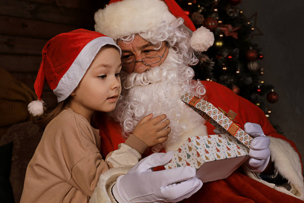 Santa Claus and child at home. Christmas gift. Family holiday concept - Photo, image
