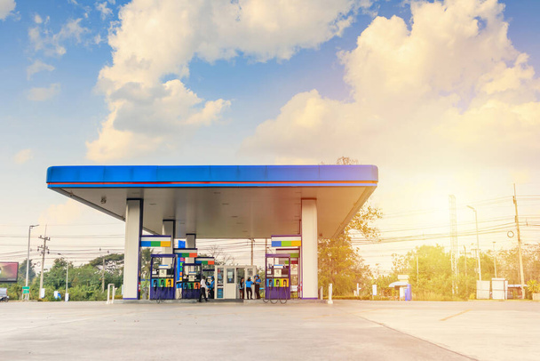 Bulutları ve mavi gökyüzü olan benzin istasyonu. - Fotoğraf, Görsel