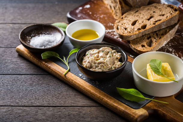 Tuňák namazaný čerstvým plátkem chleba, šalvějovým máslem, olivovým olejem a solí na venkovském dřevěném stole  - Fotografie, Obrázek
