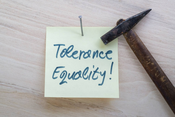 Слова толерантность и равенство написаны на желтой наклейке - Фото, изображение
