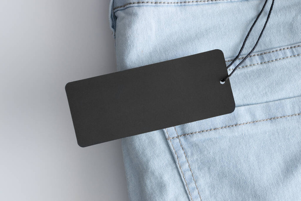 Black clothing tag mockup on a jeans. - Photo, Image