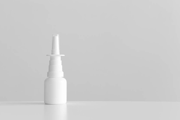 Witte neusspray fles mockup met lege kopieerruimte op een witte tafel. - Foto, afbeelding