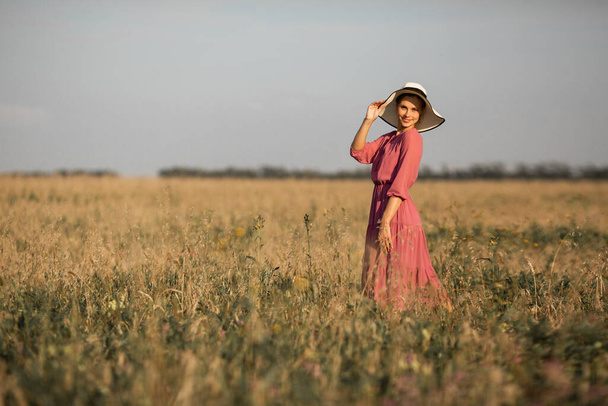 beautiful young woman in hat in summer field - Фото, изображение