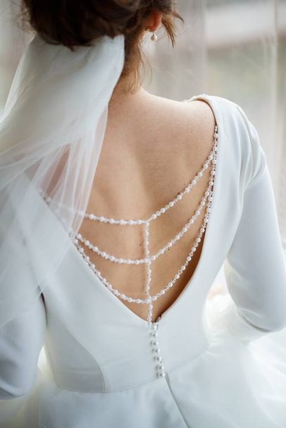 Bride zips zipper on her wedding white dress - Foto, immagini