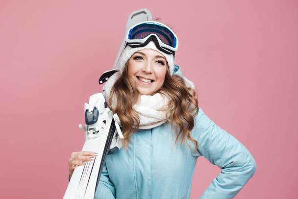fun skier is preparing to ski. Young woman in equipment and with skis, - Фото, изображение