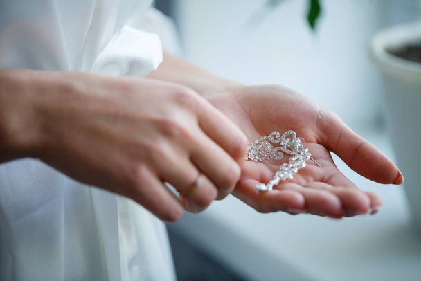 bride puts on wedding jewelry on the wedding day - Фото, зображення
