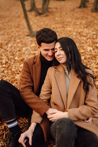 Lovely couple having fun together in the autumn forest. Fashion couple enjoying autumn weather. Fashion, lifestyle and autumn mood. - Φωτογραφία, εικόνα