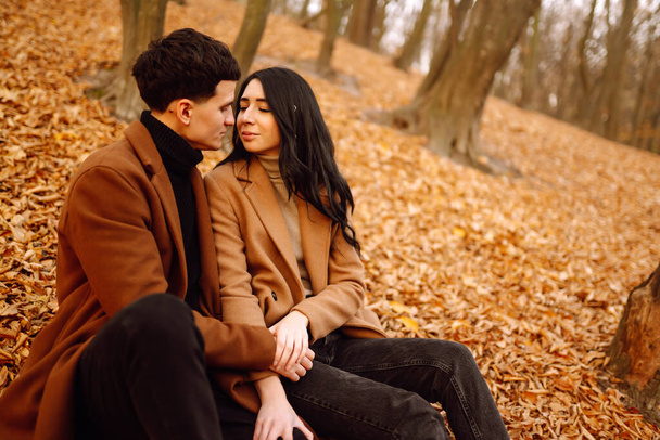 Lovely couple having fun together in the autumn forest. Fashion couple enjoying autumn weather. Fashion, lifestyle and autumn mood. - Photo, Image