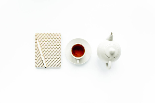 Feminine trendy home: diary, teapot, tea mug and white pen. Flat lay, top view - Photo, Image