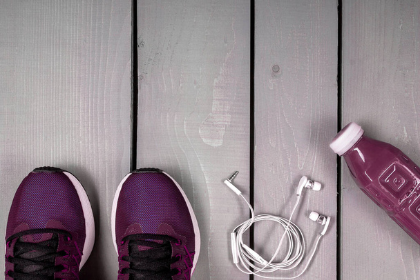 Bovenaanzicht vrouwen trainingsuitrusting, Vrouwelijke sportuitrustingen, roze sport op grijze houten achtergrond, Bovenaanzicht, vlak gelaagd - Foto, afbeelding