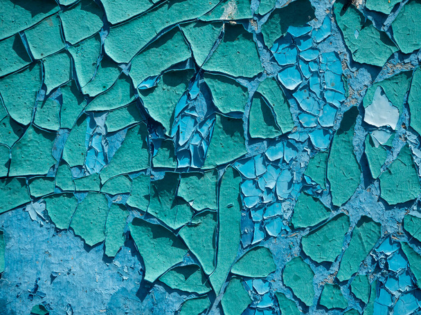 de oude verweerde schilferende verf is blauw op de muur. Close-up, achtergrond, textuur - Foto, afbeelding