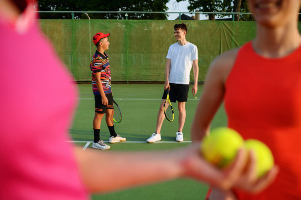 Karışık çiftler tenis, oyuncular oyuna dışarıda başlıyor. Aktif sağlıklı yaşam tarzı, raket ve topla spor, raketlerle spor. - Fotoğraf, Görsel