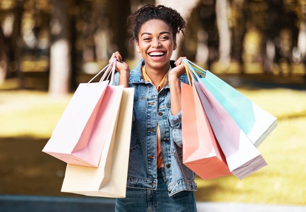 Iloinen musta tyttö jälkeen ostokset Holding Shopper Laukut seisoo ulkopuolella - Valokuva, kuva