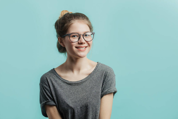 Positive girl with hairbun looking at camera with joyful and charming smile. - Foto, Bild