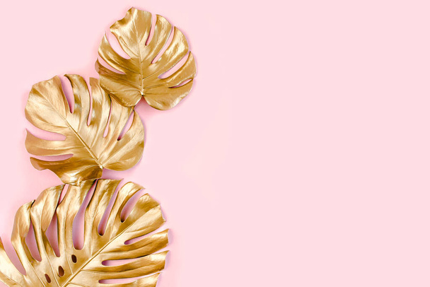 Gold tropical palm leaves Monstera on pink background. Flat lay, top view minimal concept. - Zdjęcie, obraz