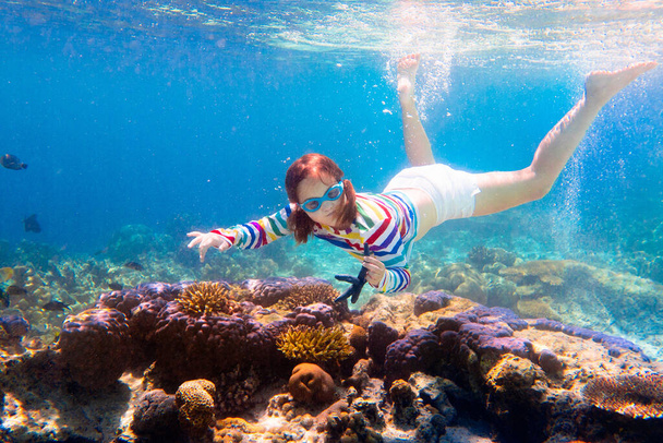 Child snorkeling. Kids swim underwater. Beach and sea summer vacation with children. Little girl watching coral reef fish. Marine life on exotic island. Kid swimming and diving with snorkel and mask. - Zdjęcie, obraz